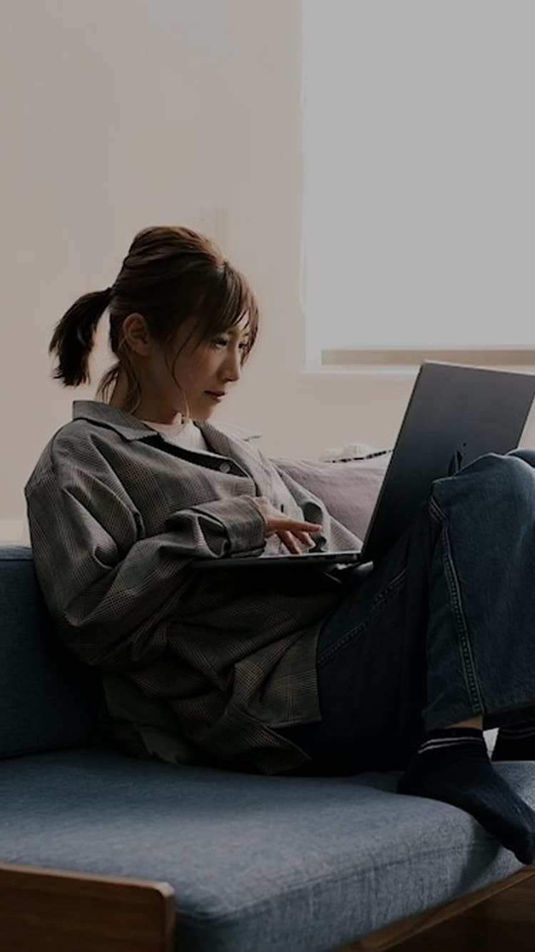 omicoshi代表がソファでパソコンを見ている